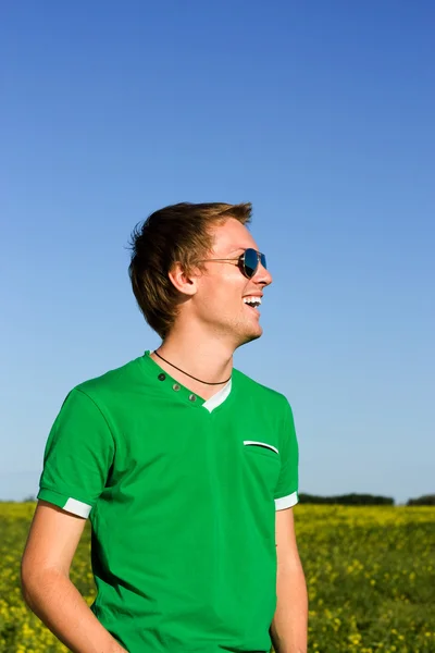 Mladý muž se směje v sluneční brýle — Stock fotografie