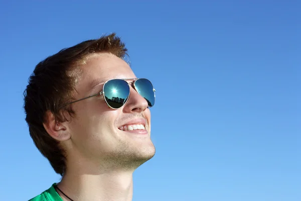 Joven se ríe en gafas de sol — Foto de Stock