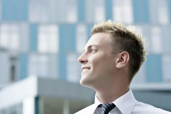 Випадковий бізнесмен, що стоїть у корпоративному офісному лобі, посміхається — стокове фото