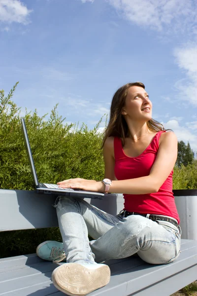 Chica joven positiva con ordenador portátil — Foto de Stock