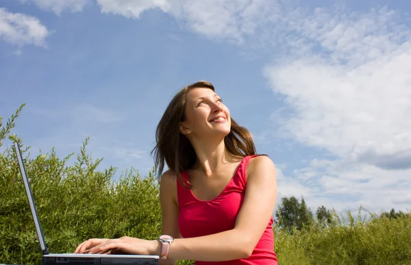 Positive young lady is looking up. Laptop — Stock Photo, Image