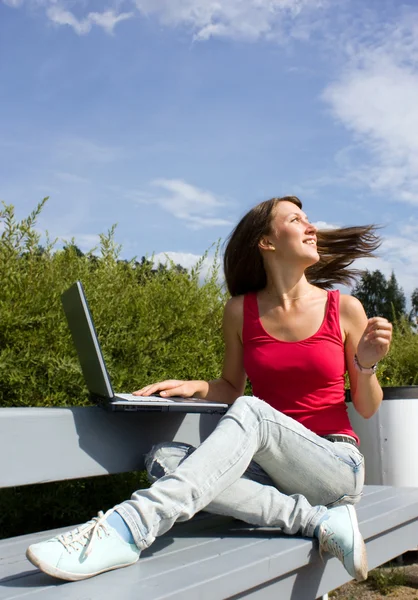 Unga casual kvinna som arbetar på laptop utomhus — Stockfoto