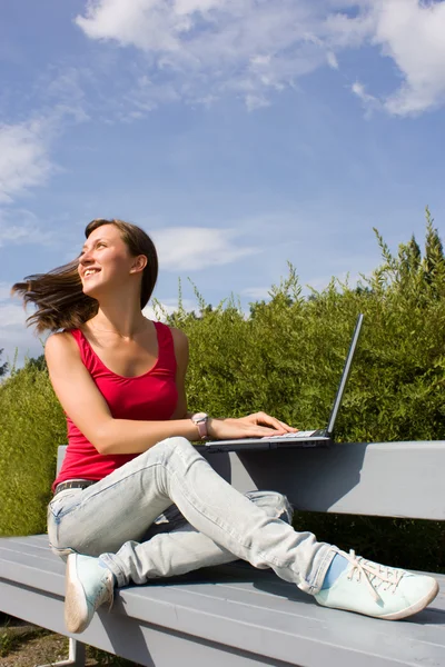 Mujer casual joven que trabaja en el ordenador portátil al aire libre — Foto de Stock