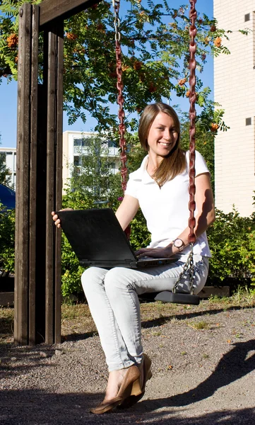 Chica feliz en la calle con un ordenador portátil —  Fotos de Stock