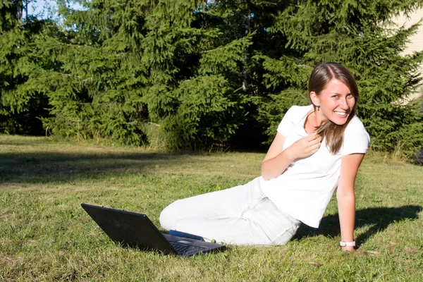 Młoda kobieta pracuje na laptopie odkryty — Zdjęcie stockowe