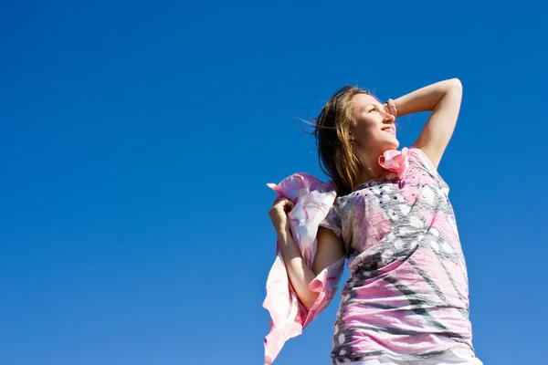 Joyeux jeune femme jouant avec son écharpe près de la mer, dans la victoire — Photo