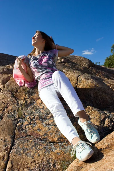 Jovem positiva contra a rocha no verão — Fotografia de Stock