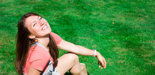 Jovem morena feliz na grama verde — Fotografia de Stock