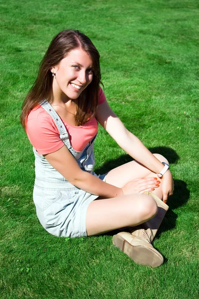 Šťastná mladá bruneta na zelené trávě — Stock fotografie