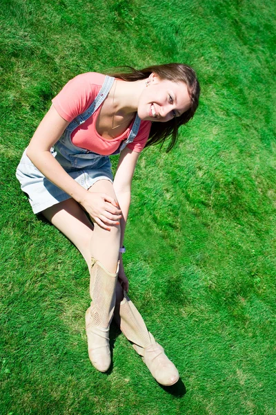 Счастливая юная брюнетка на зеленой траве — стоковое фото