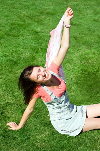 Pozitif kızın rahatlatıcı yeşil çimenlerin üzerinde — Stok fotoğraf