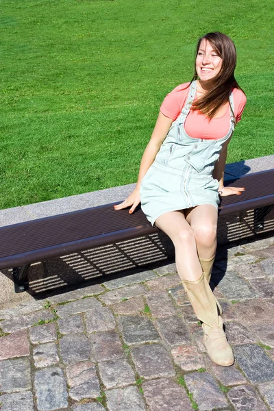 Fo bekleyen bir tahta bankta oturan genç çekici kız modeli — Stok fotoğraf