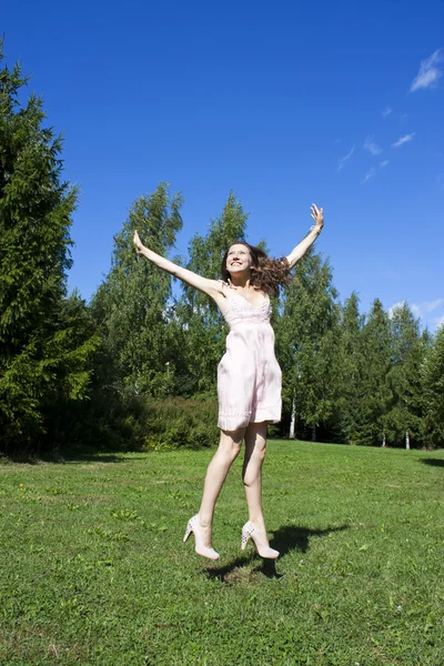 Mutlu bir genç güzel kadın mavi gökyüzü altında. — Stok fotoğraf