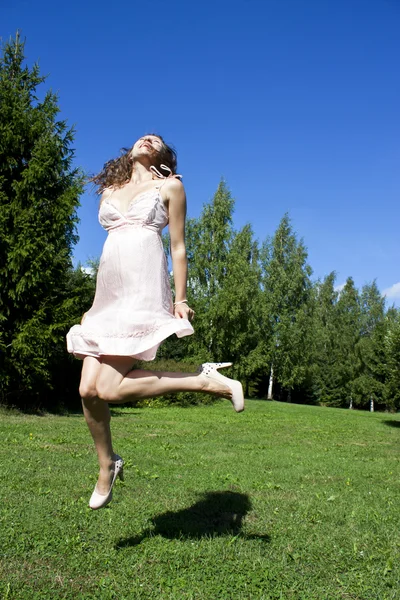 Vacker flicka hoppar i parken — Stockfoto