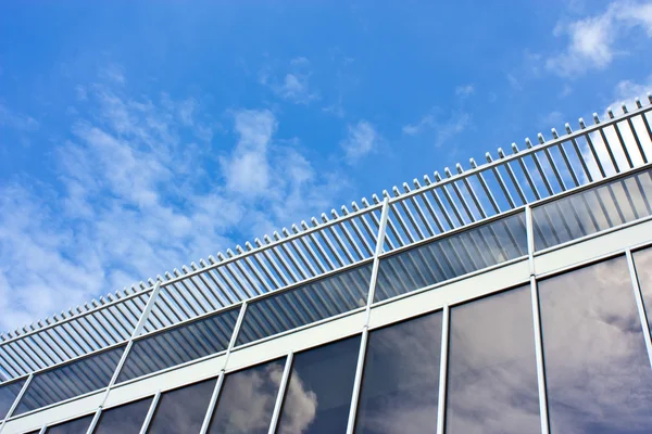 Casa de oficinas moderna. vidrio azul sobre un cielo de fondo —  Fotos de Stock