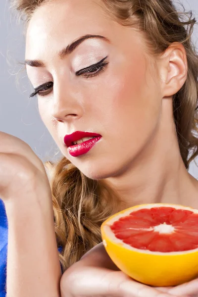 Blonde met grapefruit, met rode lippenstift — Stockfoto