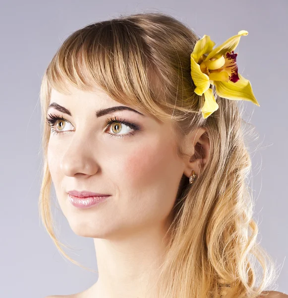 Ung vacker kvinna med gul blomma — Stockfoto