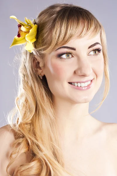 Junge schöne Frau mit gelben Blume — Stockfoto