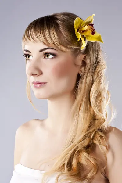 黄色の花を持つ若い美しい女性 — ストック写真