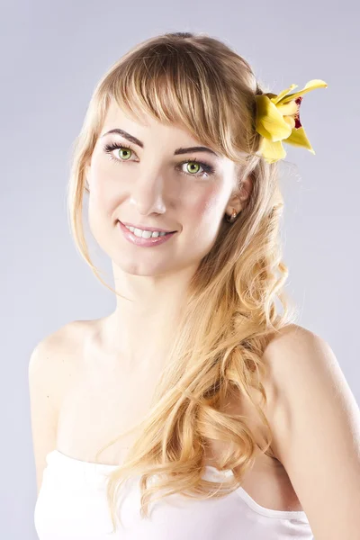 Junge schöne Frau mit gelben Blume — Stockfoto
