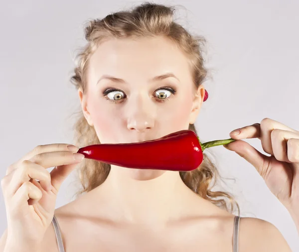 Gyönyörű nő fogak evés red hot chili paprika — Stock Fotó