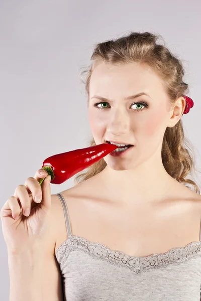 Schöne Frauenzähne, die rote Chilischote essen — Stockfoto
