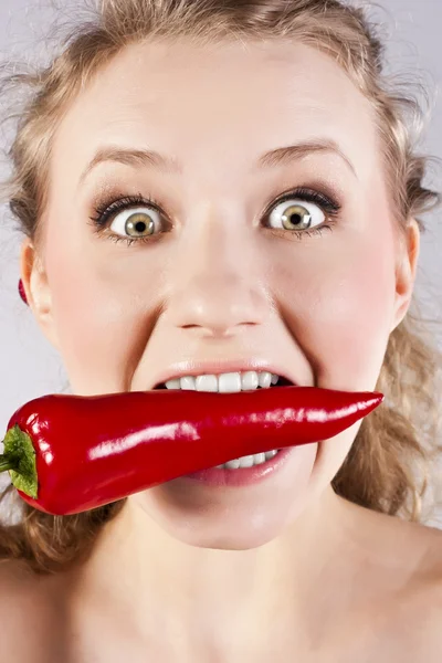 Красивая женщина зубы едят красный острый перец чили — стоковое фото