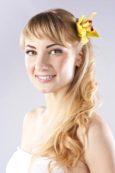 Jeune belle femme avec fleur jaune — Photo