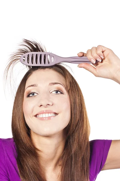 Attraente donna sorridente spazzolando il suo sentire — Foto Stock