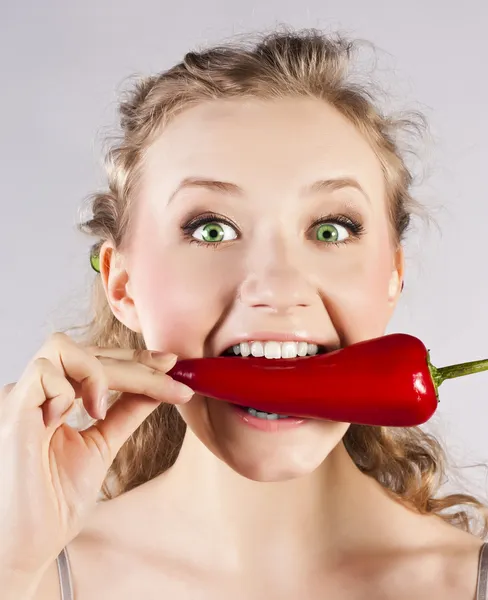 Красива жінка зуби їсть червоний гарячий перець чилі — стокове фото