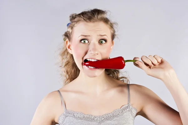 Bela mulher dentes comendo pimenta quente vermelha — Fotografia de Stock