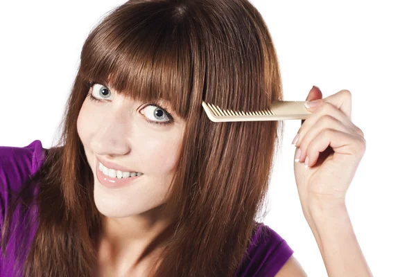 Brunette brushing her hair, in studio — Stock Photo, Image