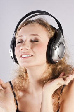 Pretty woman listening, and enjoying music clipart