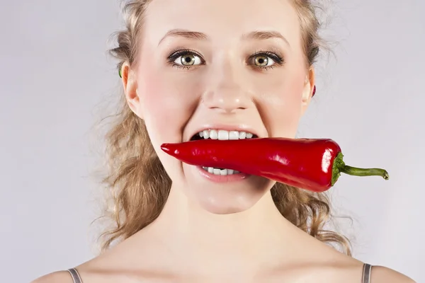 Güzel kadın diş yeme kırmızı biber biber sıcak — Stok fotoğraf