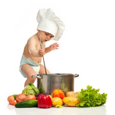 Little boy with ladle, casserole, and vegetables