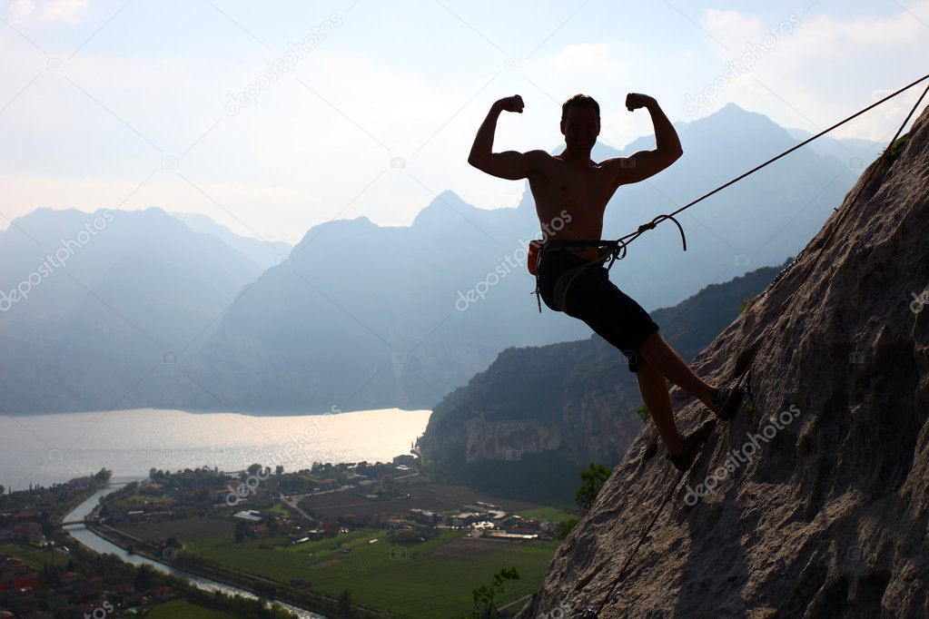 Silhouette of a rock climber flexing biceps