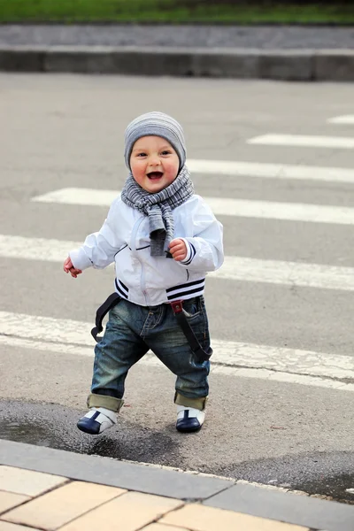 Menino atravessando uma rua — Fotografia de Stock