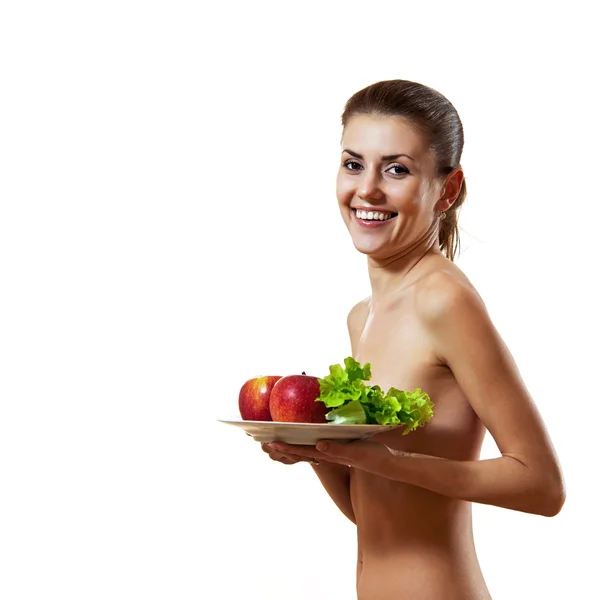 Jeune femme tenant assiette avec des pommes et de la laitue — Photo