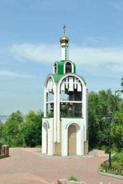 yemyeşil ağaçlar ve hafif bulutlu mavi gökyüzü beyaz çan kulesi aykırıdır
