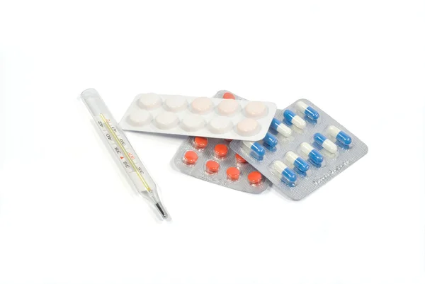 El termómetro clínico y los envases con pastillas — Foto de Stock