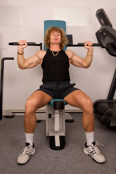 男人在健身房用举重的机器进行健身训练 — 图库照片
