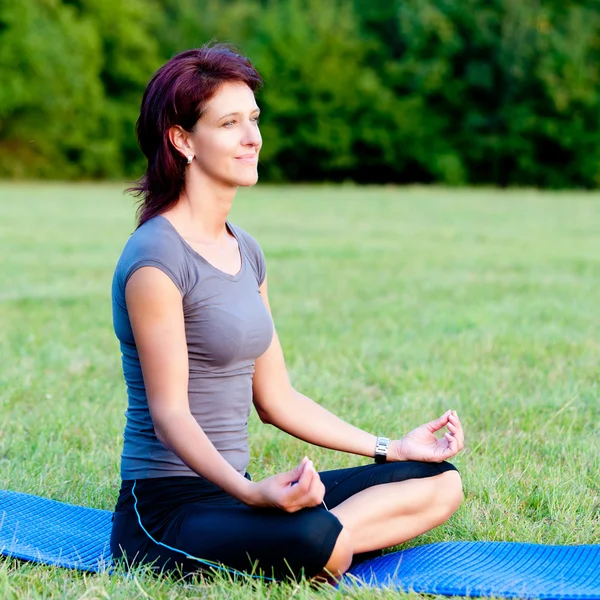 Donna pratica yoga all'aperto nel parco — Foto Stock