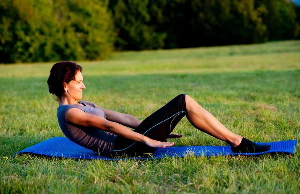 Mujer practica yoga al aire libre en parque —  Fotos de Stock