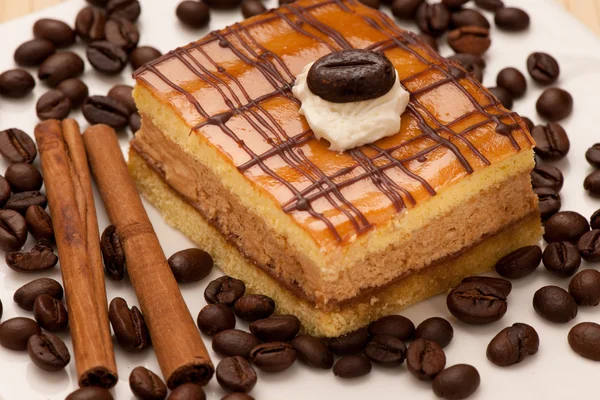 Кавовий торт на тарілці, прикрашений корицею та кавовими зернами — стокове фото