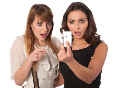 Two attractive young women checking a short message clipart