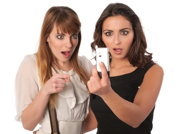 Två vackra unga kvinnor kontroll ett kort meddelande — Stockfoto