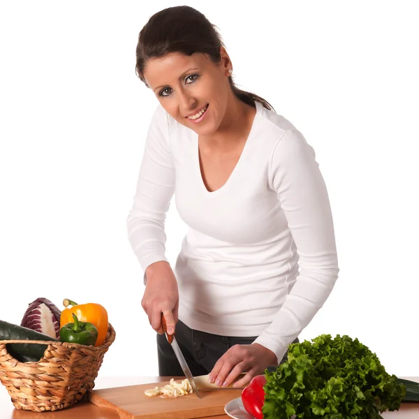 Attraktive junge Frau schneidet Gemüse und bereitet Mahlzeit zu — Stockfoto