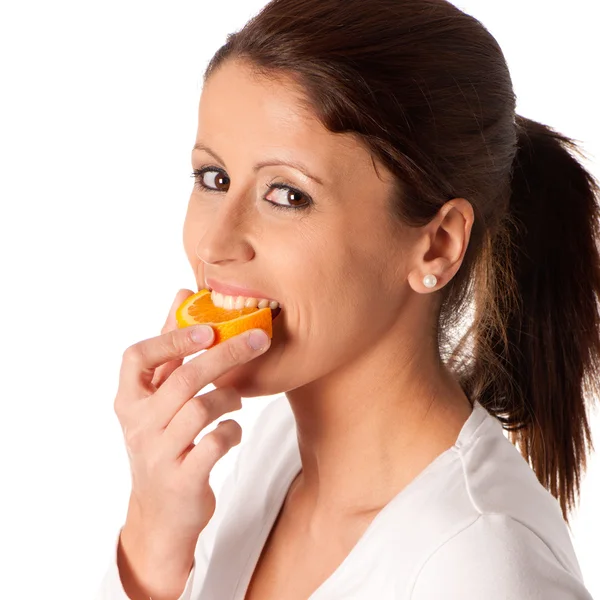 Linda chica joven comiendo una rebanada de fruta naranja — Foto de Stock