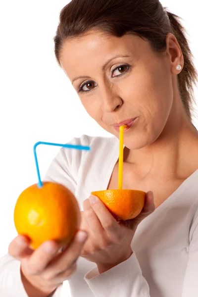 迷人的年轻女子，喝着一杯橙汁 — 图库照片