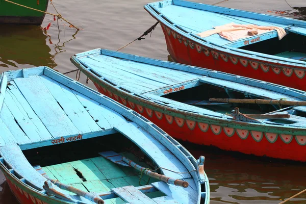 Colorful boats on brown waters of Ganges river, Varanasi, India Stock Photo